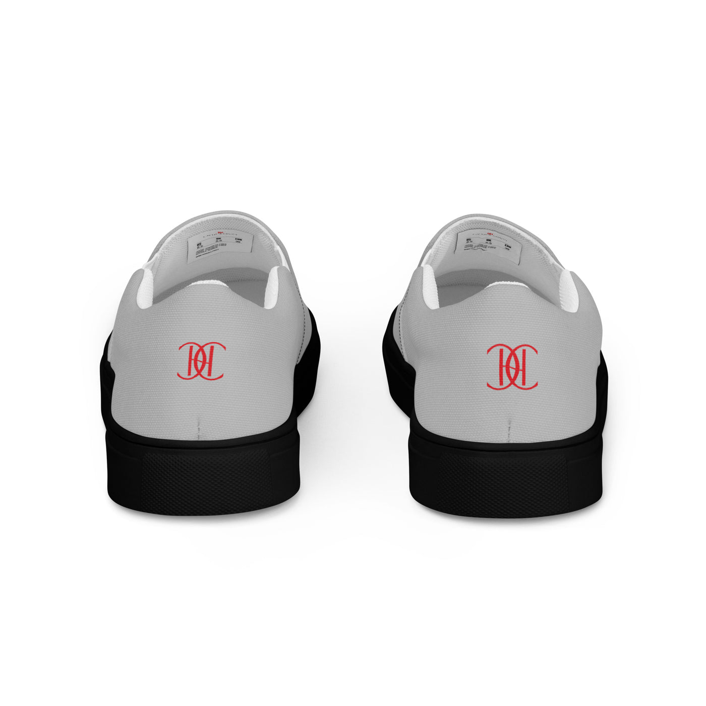 Grey slip-on sneakers with black soles, featuring bold red Cachy’s Urban logo on the front and branded insoles