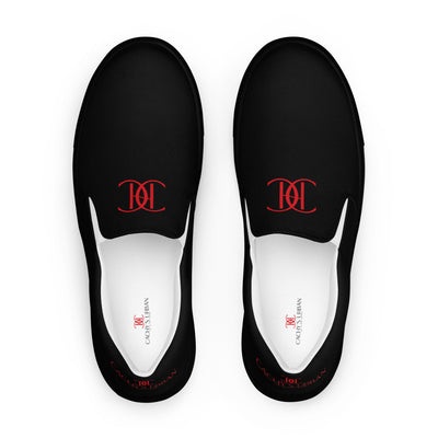 Black slip-on sneakers with red Cachy’s Urban logo on the upper, paired with black soles and white inner lining