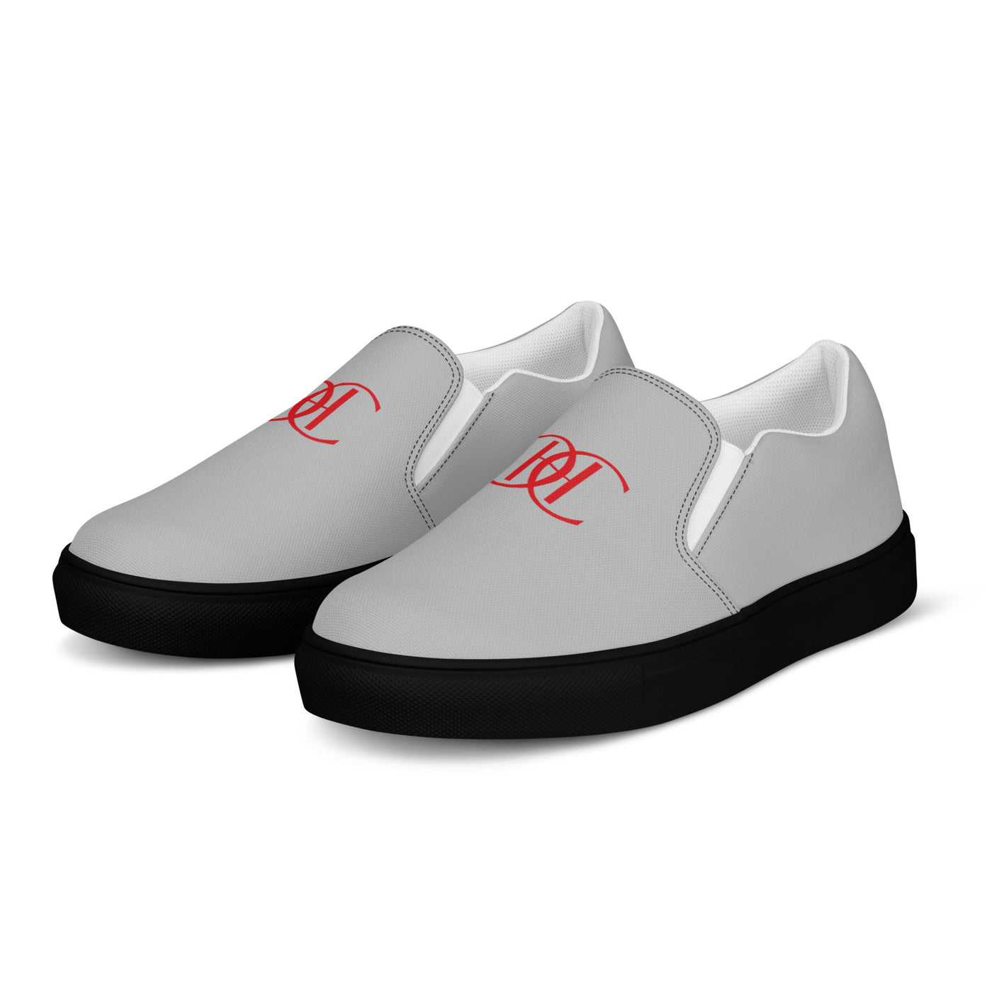 Grey slip-on sneakers with black soles, featuring bold red Cachy’s Urban logo on the front and branded insoles