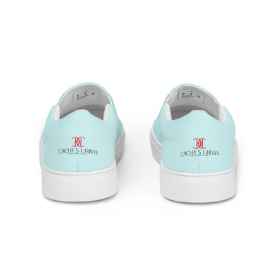 Light blue slip-on canvas shoes with red Cachy’s Urban monogram logo on the upper front and branded insoles