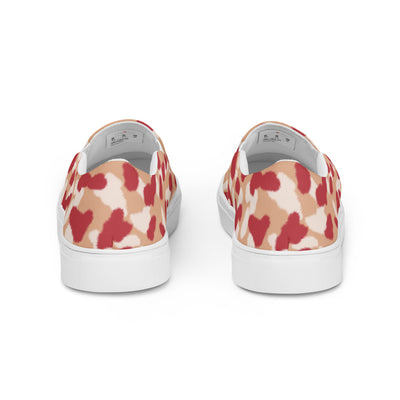 Beige slip-on canvas shoes with bold red and cream abstract leopard print pattern, featuring Cachy’s Urban branded insoles