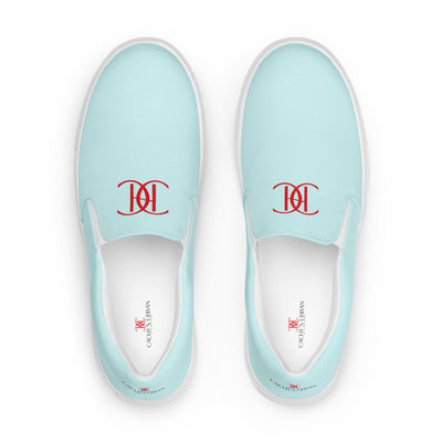 Light blue slip-on canvas shoes with red Cachy’s Urban monogram logo on the upper front and branded insoles