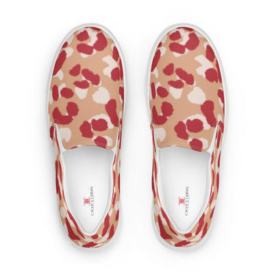 Beige slip-on canvas shoes with bold red and cream abstract leopard print pattern, featuring Cachy’s Urban branded insoles
