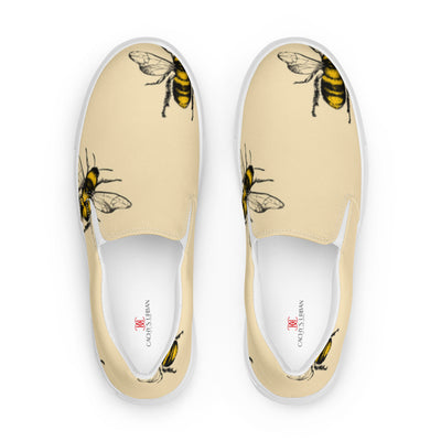 Beige slip-on canvas shoes with a bold bee pattern design and Cachy’s Urban branded insoles