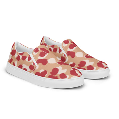 Beige slip-on canvas shoes with bold red and cream abstract leopard print pattern, featuring Cachy’s Urban branded insoles